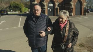 Kevin Hogg and Ann Ming walking arm in arm and looking upset