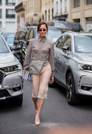 Chriselle Lim seen wearing a grey jacket, sheer skirt, blue bag, heels outside Fendi during Paris Fashion Week - Haute Couture Fall Winter 2022 2023 : Day Four on July 07, 2022 in Paris, France