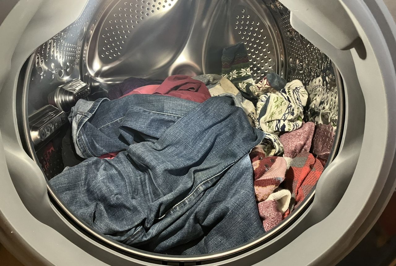LG 5.0 cu. ft. Mega Capacity Smart Front Load All-in-One Washer Dryer Combo with a load of laundry demonstrating internal light