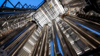 photo looking up at four huge stainless-steel cylinders inside an open-air high bay.