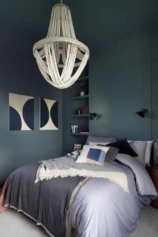 dark blue bedroom with painted ceiling and statement chandelier