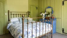 green bedroom with brass bed