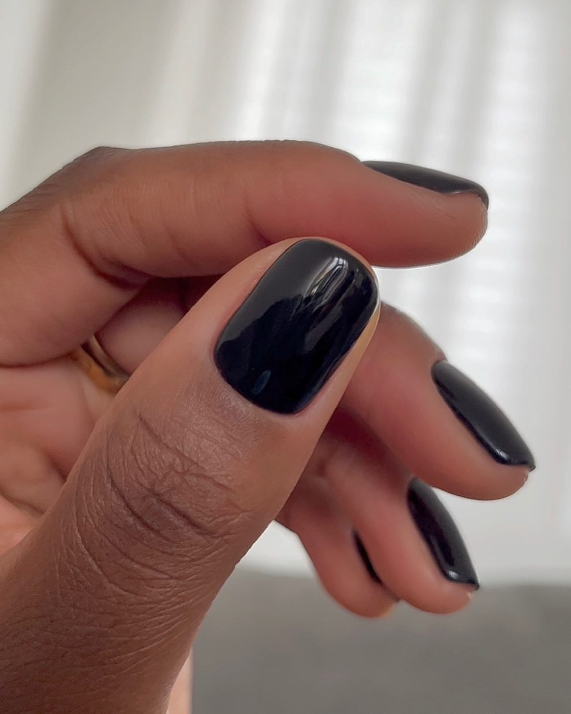 A close-up image of a glossy black manicure