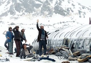 a group of stranded passengers outside of a crashed plane in the movie society of the snow