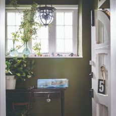 A green-painted hallway with an arched white front door