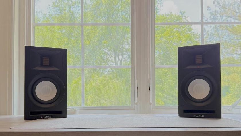 Fluance Ri71 bookshelf powered speakers on a windowsill, with trees outside the window.