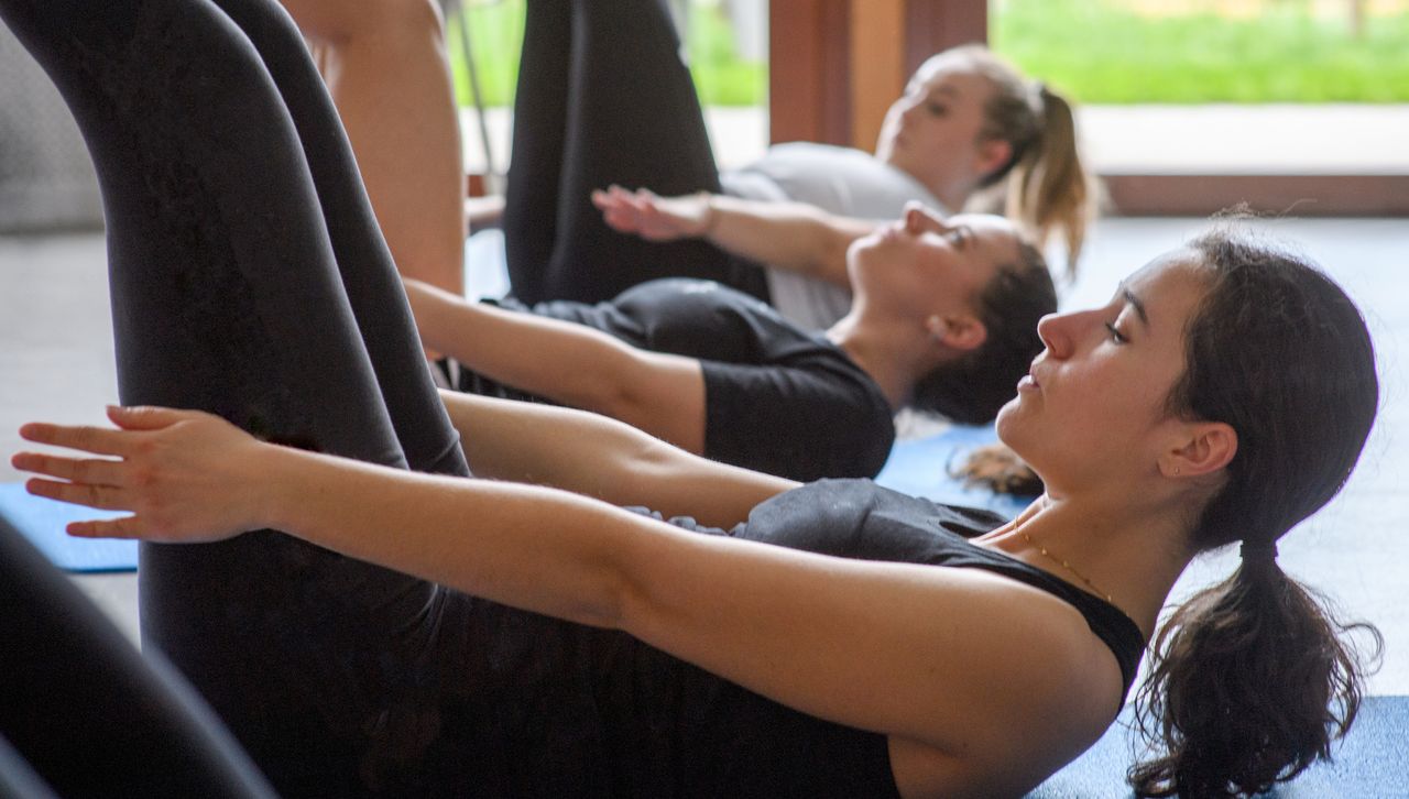 Women in Pilates class performing the hundred exercise