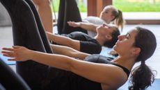 Women in Pilates class performing the hundred exercise