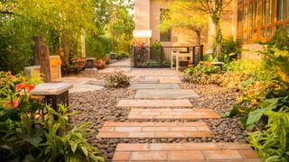 garden with stepping stones made of brick leading through gravel path with planting on either side