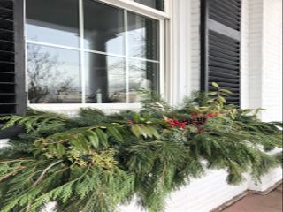 exterior window sill with Christmas foliage garland