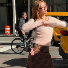 vivian wears pink fuzzy wrap sweater and a brown skirt with red socks and black flats