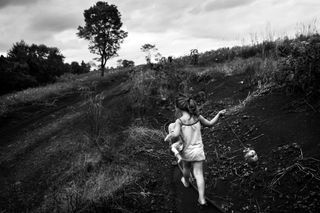 A girl runs across the fields