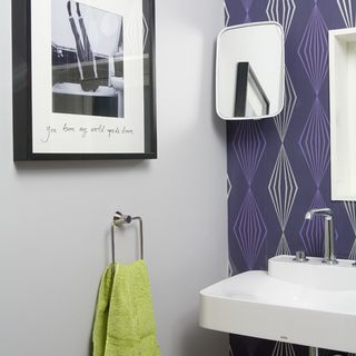 cloak room with photoframe on wall and white washbasin
