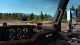 A Christmas-themed mug resting on the dashboard of a truck cab in Euro Truck Simulator 2.