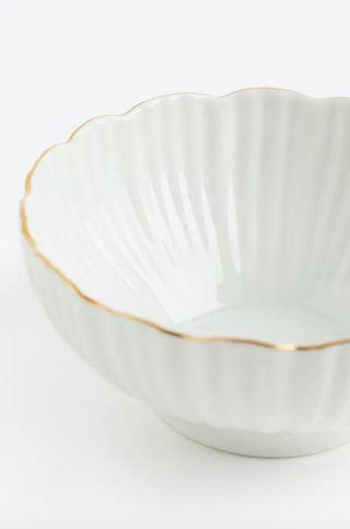 white bowl with scallop design and gold rim