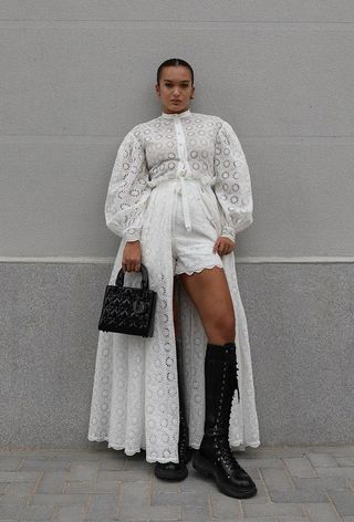a woman's shirtdress outfit with a white eyelet maxi opened up to expose matching shorts and knee-high black combat boots
