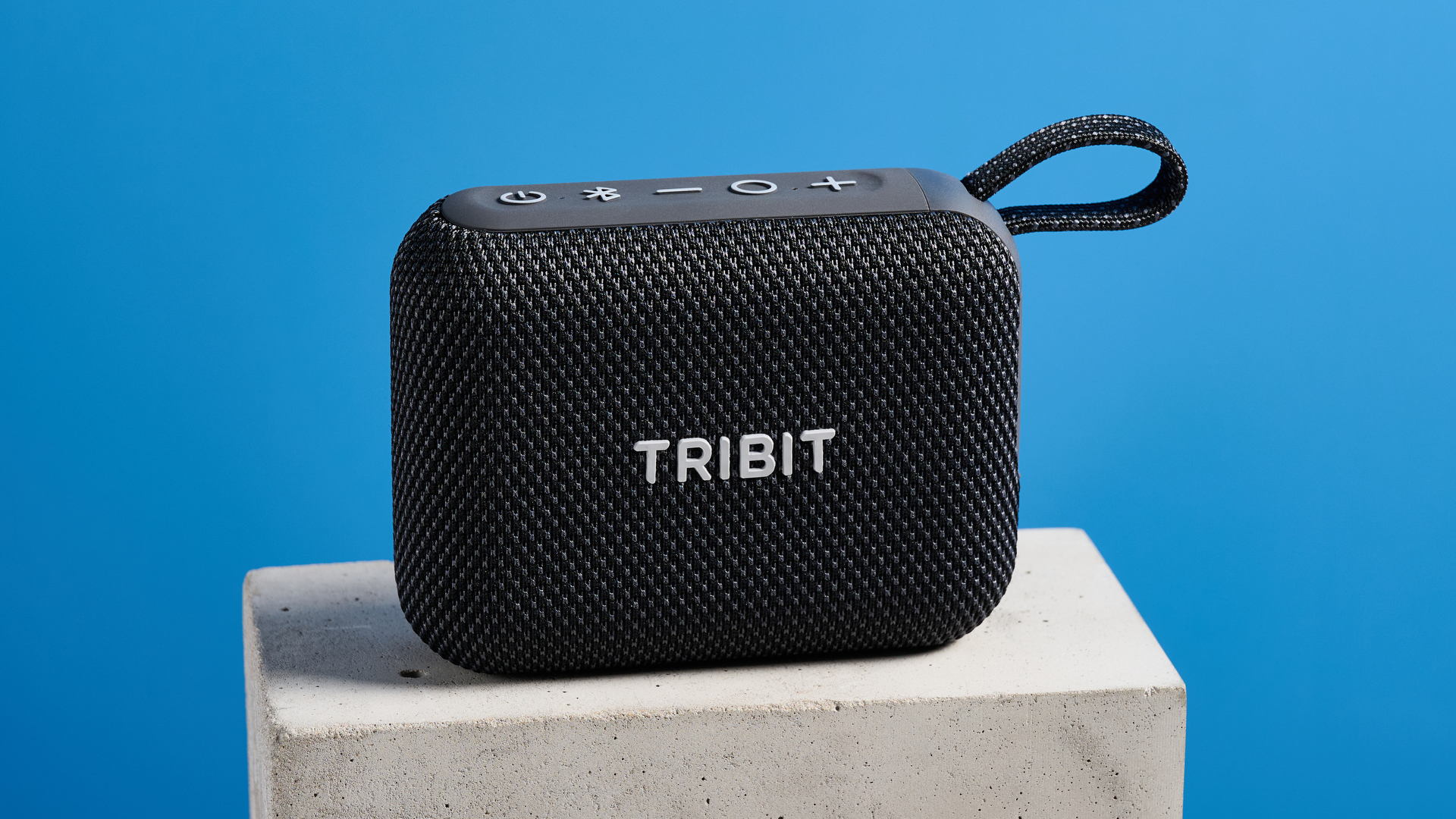 The Tribit PocketGo speaker in black photographed on a blue background.