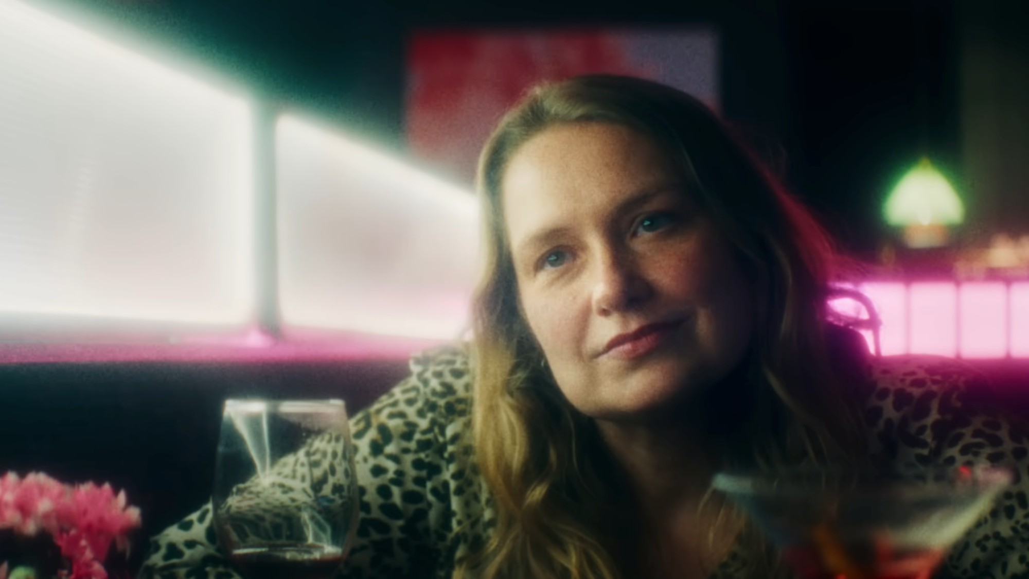 A close up of Merritt Weaver in a bar with a leopard pattern shirt on in Primetime.