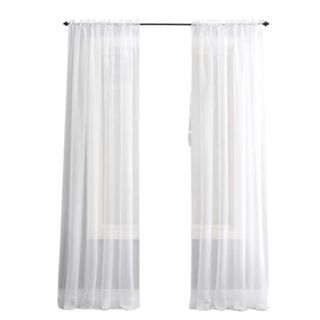 Two white curtain panels on a silver curtain pole