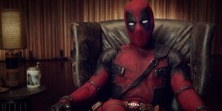 Deadpool sitting in a leather chair, speaking to the audience
