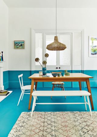 dining room with a blue floor and walls with white painted walls at the top.