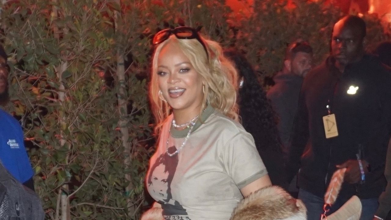 Rihanna attends Coachella 2024 in a band t shirt diamond necklaces and a fur coat