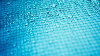 Close up of water droplets on grid surface 