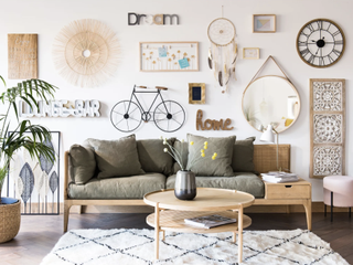 Green boho style sofa in a living room with gallery wall