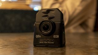 The Zoom Q2n-4K camcorder on a table in a live music venue