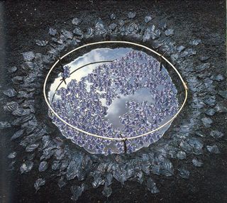 An environmental artwork depicting a the small "lake" dug into dark soil, filled with water and topped off with bluebell blossoms.