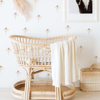 Falling flowers fabric wall stickers with a wooden baby crib and a white blanket on a wooden floor