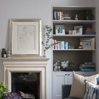 A living room with a bookcase built into an alcove decorated with books and home accessories