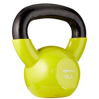 Kettlebell with yellow vinyl body and black cast iron handle on white background. 