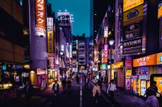 Tokyo street at night with neon signs and people walking