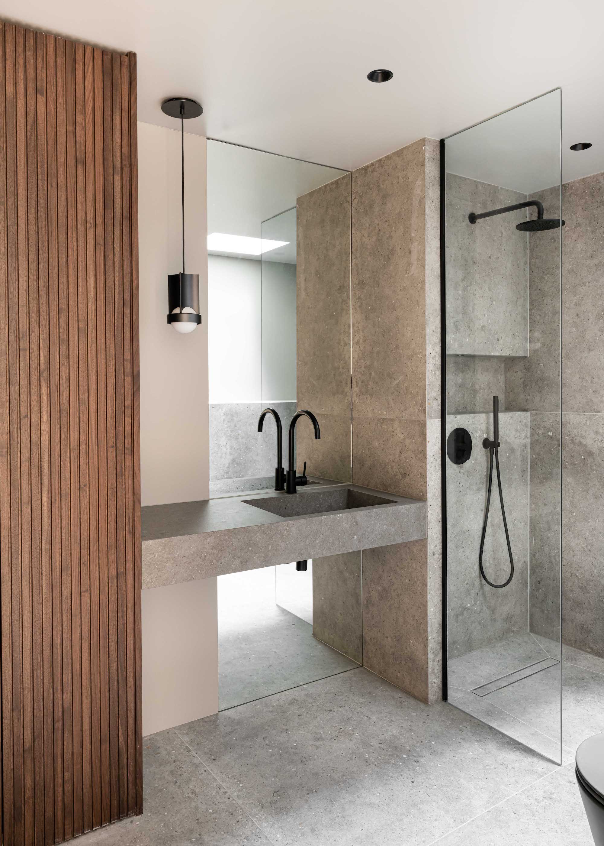 shower with grey sink and level entry floor and black brassware