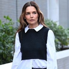 Katie Holmes wears a white shirt with a black sweater vest 