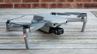 The DJI Mavic Air 2 drone on a wooden table with its arms unfolded.