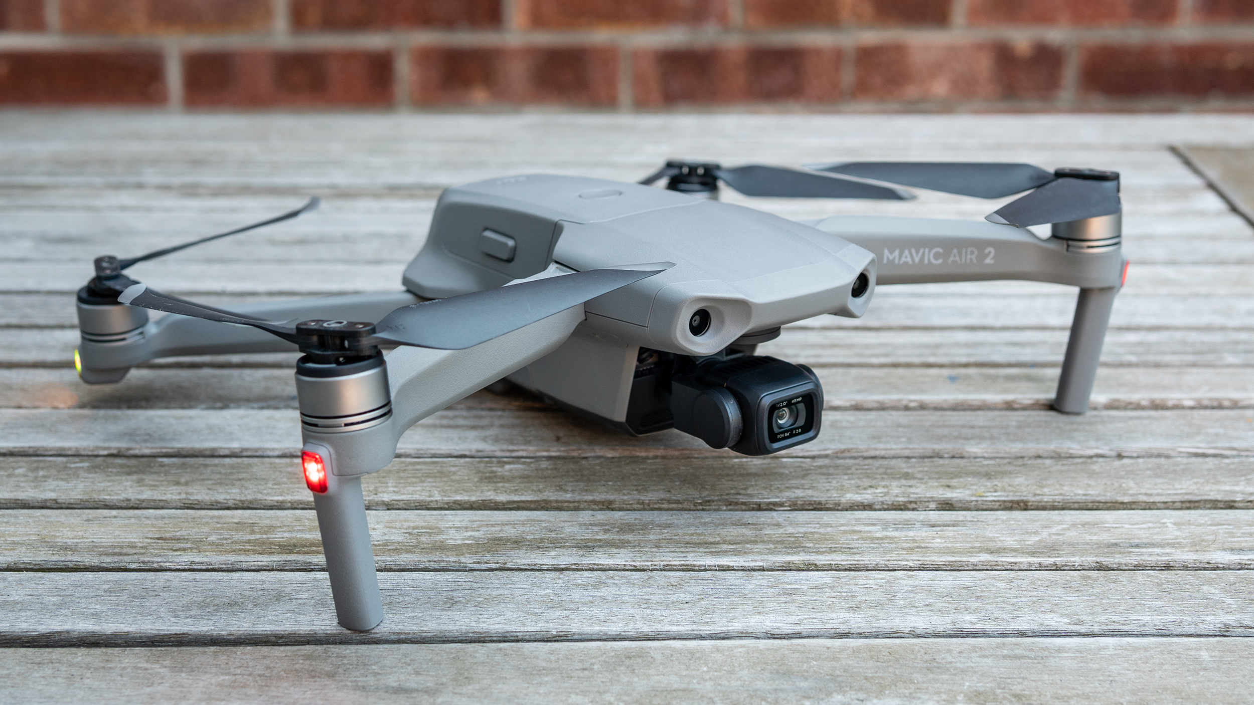 The DJI Mavic Air 2 drone on a wooden table with its arms unfolded.