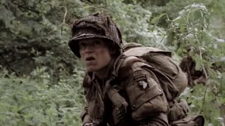 Blythe in full gear walking through the woods in Band of Brothers