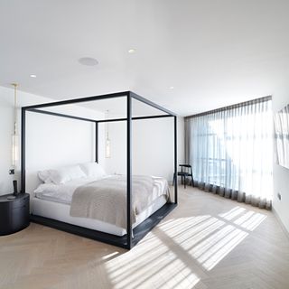bedroom with four poster bed and wooden floor
