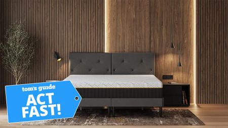 An Emma Elite mattress on a bedframe in a wood-panelled bedroom with a Tom's Guide 'Act Fast' badge