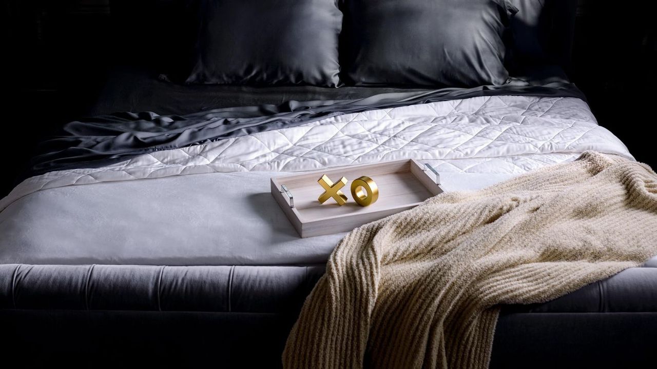 Luxome Luxury Sheet Set with a cozy throw. Two initial ornaments, reading &#039;X&#039; and &#039;O&#039;, in a tray on the bed.