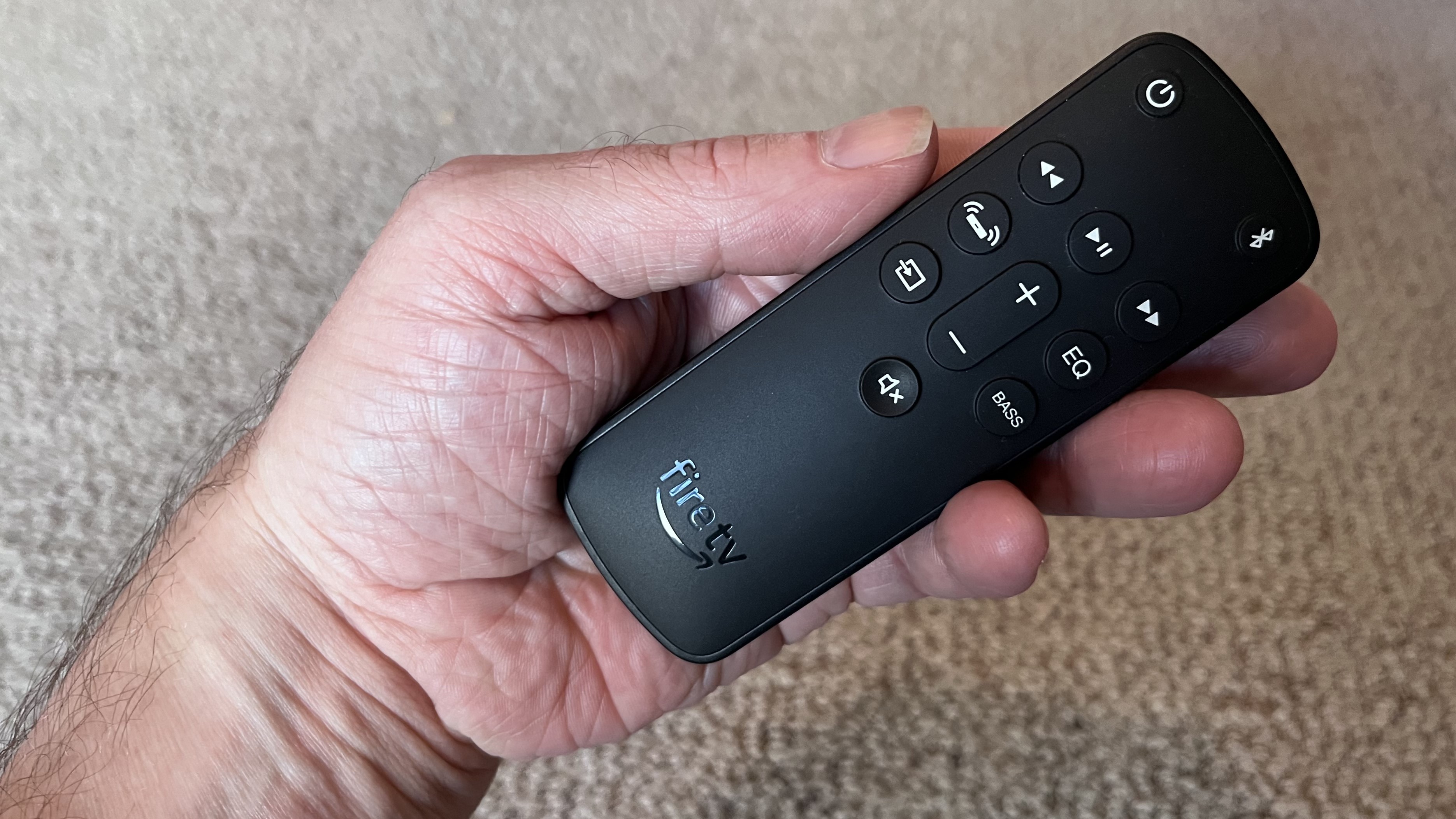 Amazon Fire TV Soundbar remote control in hand