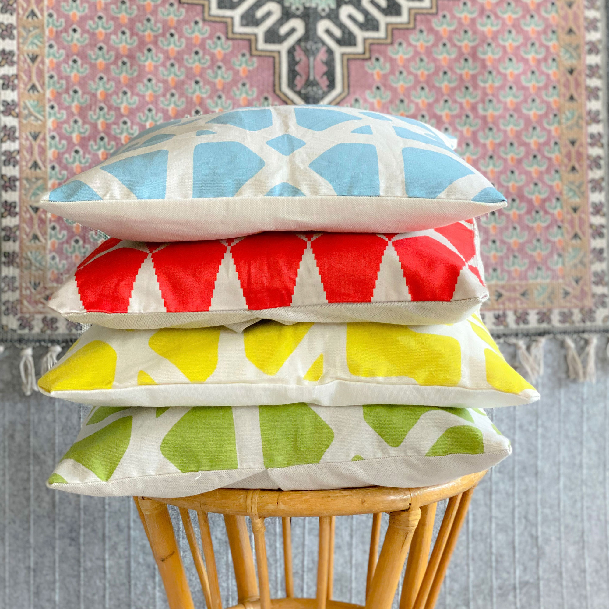 Stack of colourful patterned cushions on wooden stool