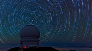 Stars spinning around an observatory in the night sky