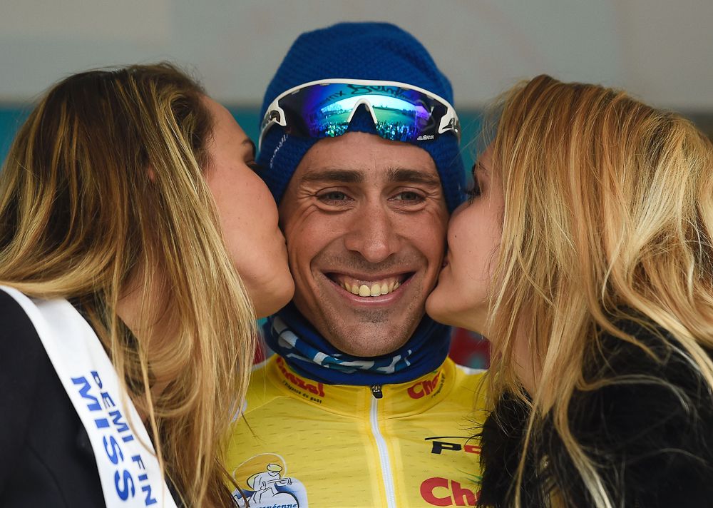 Mathieu Ladagnous of FDJ is kissed as he sports the yellow maillot of the leader on the podium, after winning the Team Time Trial on day one of the tour of 'La Mediterraneenne'