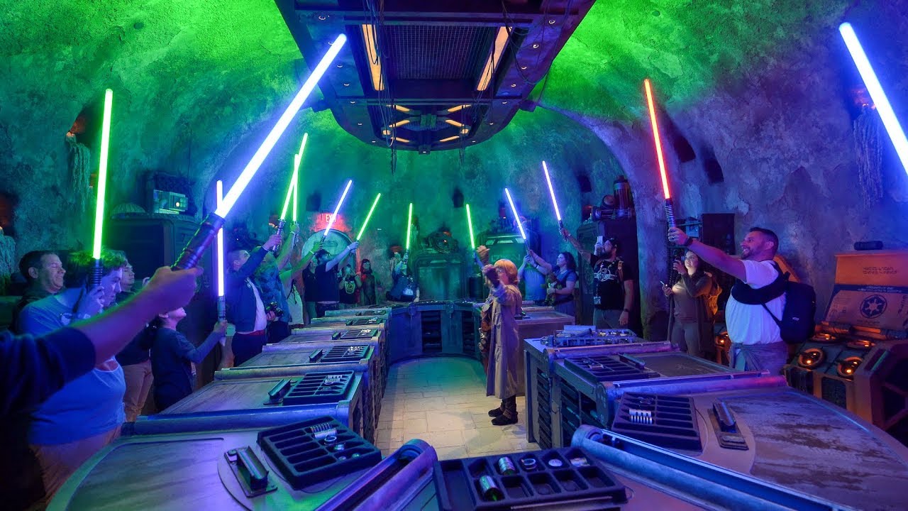Guests raising their lightsaber's at Savi's Workshop at Star Wars: Galaxy's Edge