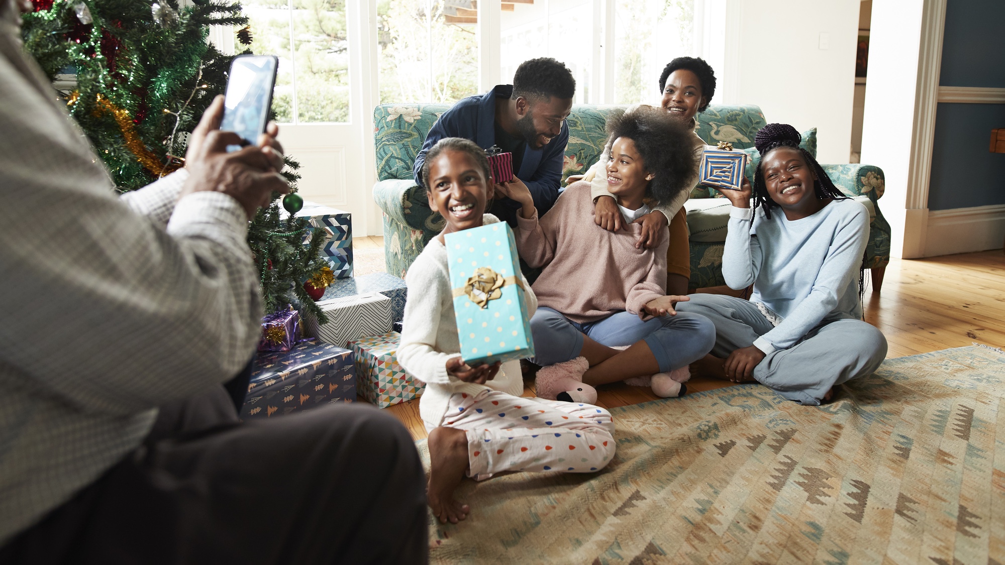 family opening presents at Christmas taking group photo