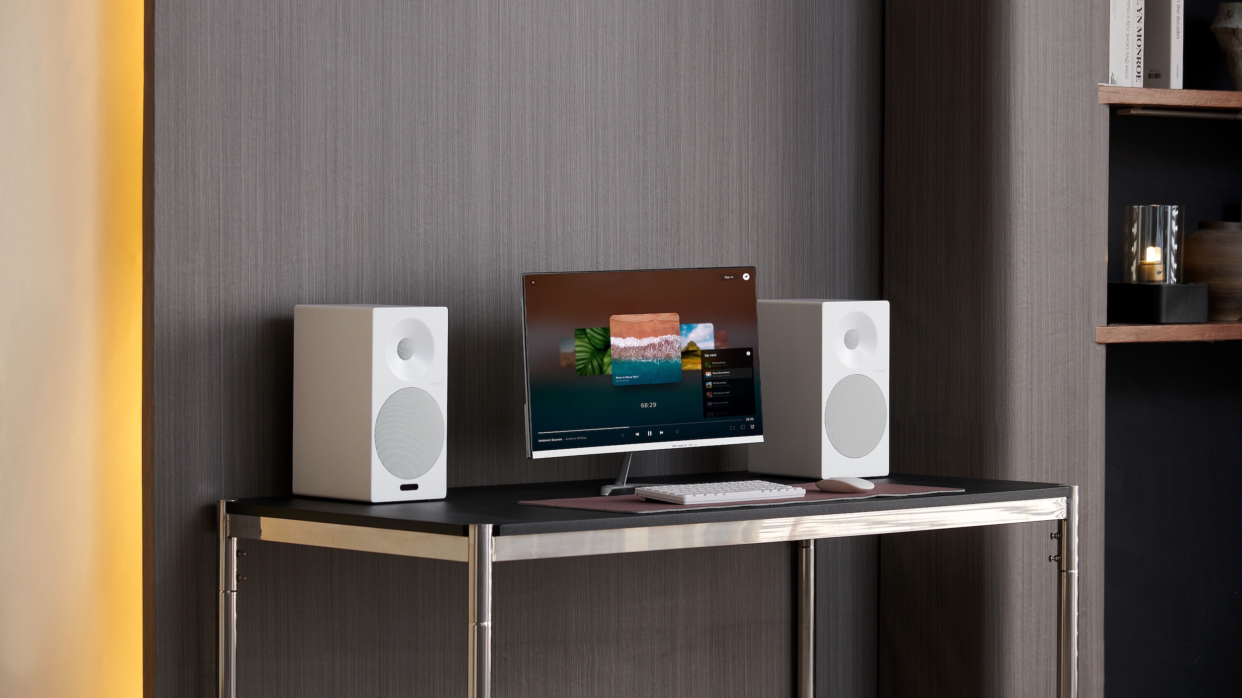 A pair of white Tangent Spectrum II X5 Active BT speakers flanking a monitor on a desk.