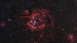 An image of a red swirling galaxy with many individual stars visible